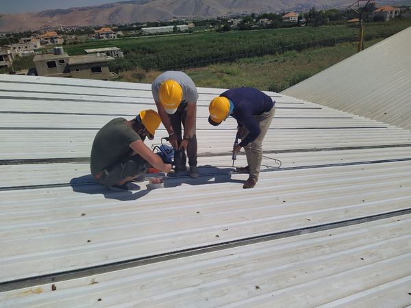 Our team wiring the array on an industrial roof